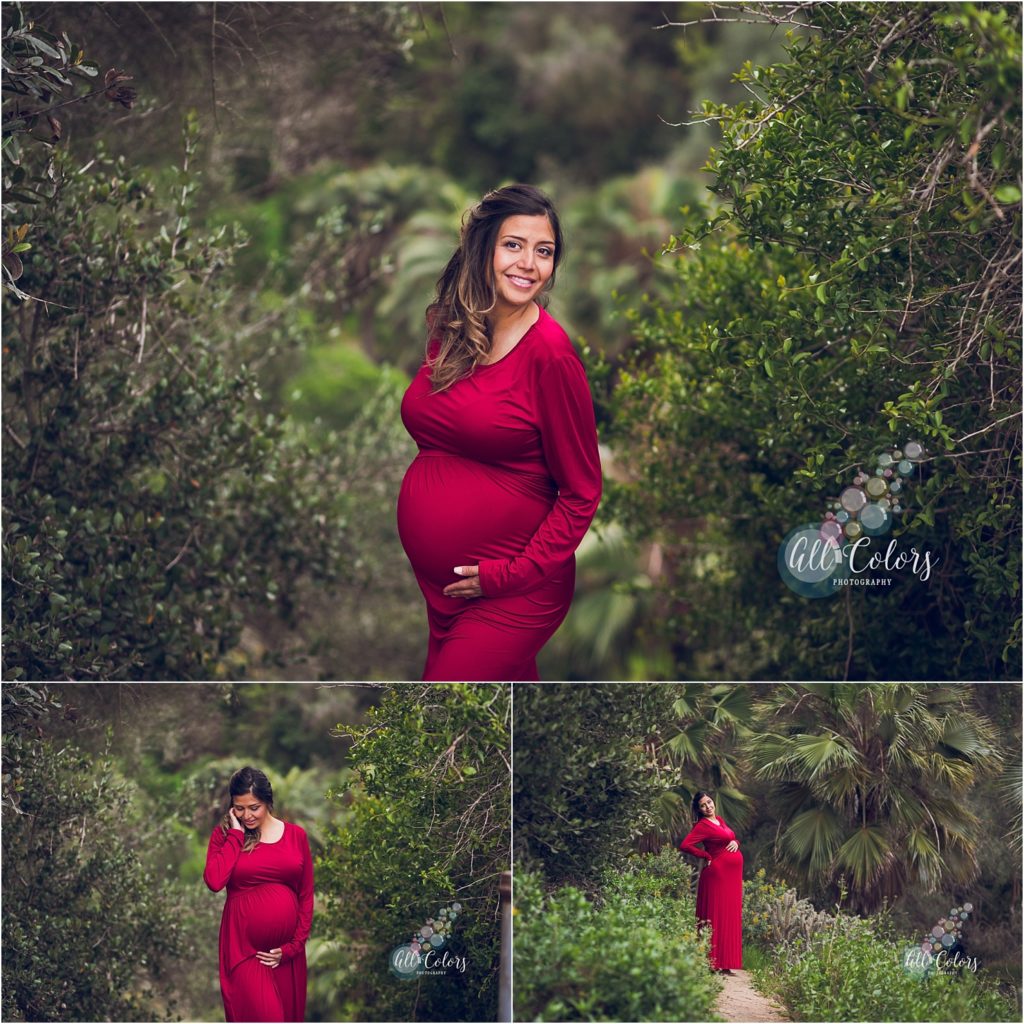 Expecting woman wearing a red dress in a lush green trail