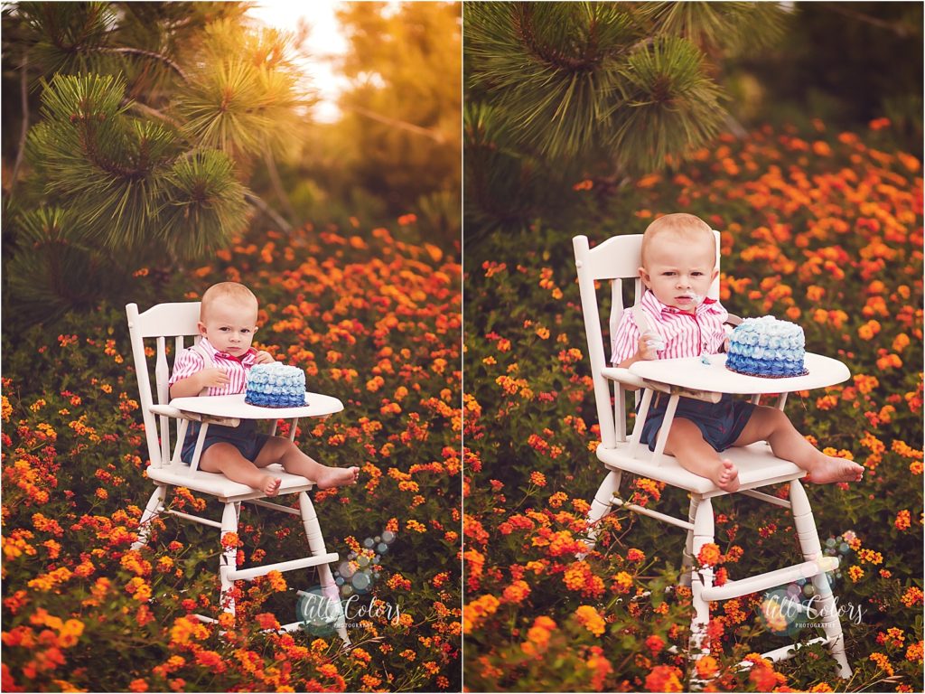 1 year old boy sitting on a vintage high chair eating a blue cake on a orange flower field. 
