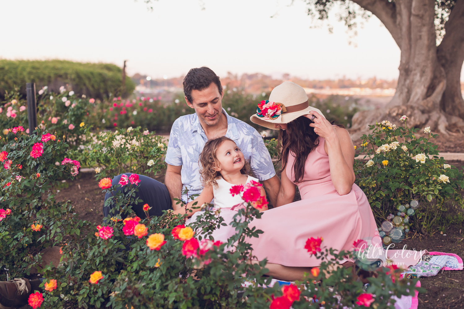 Mother, father and daughter sitting on a colorful garden
