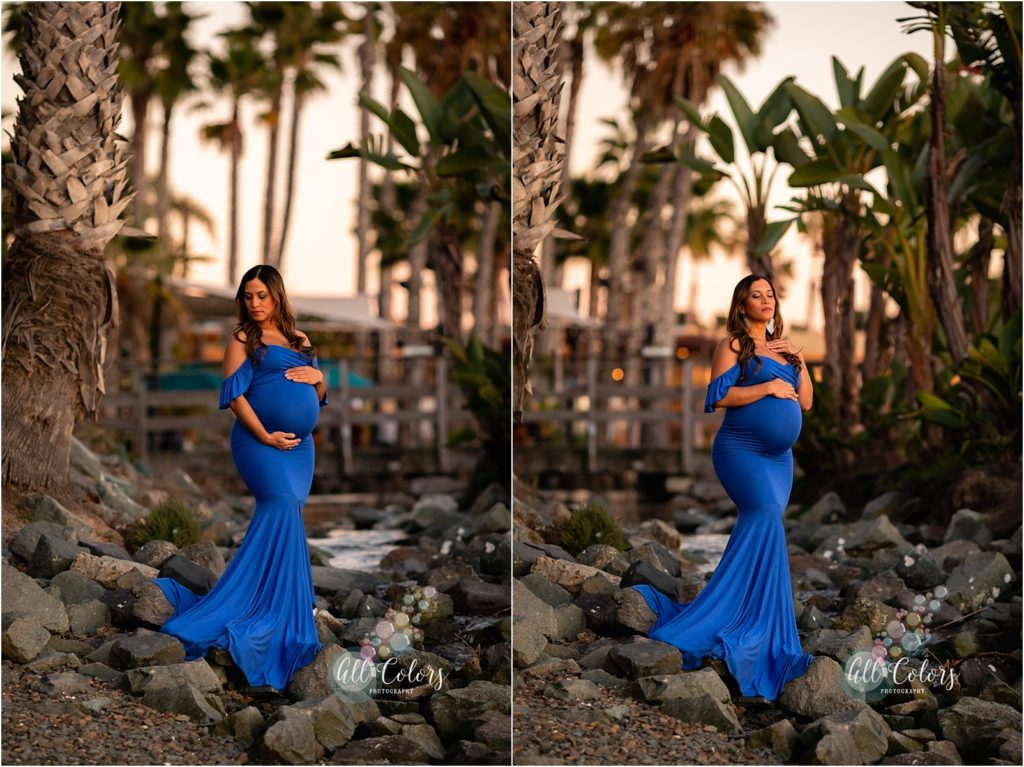 mom to be wearing a blue dress standing on rocks