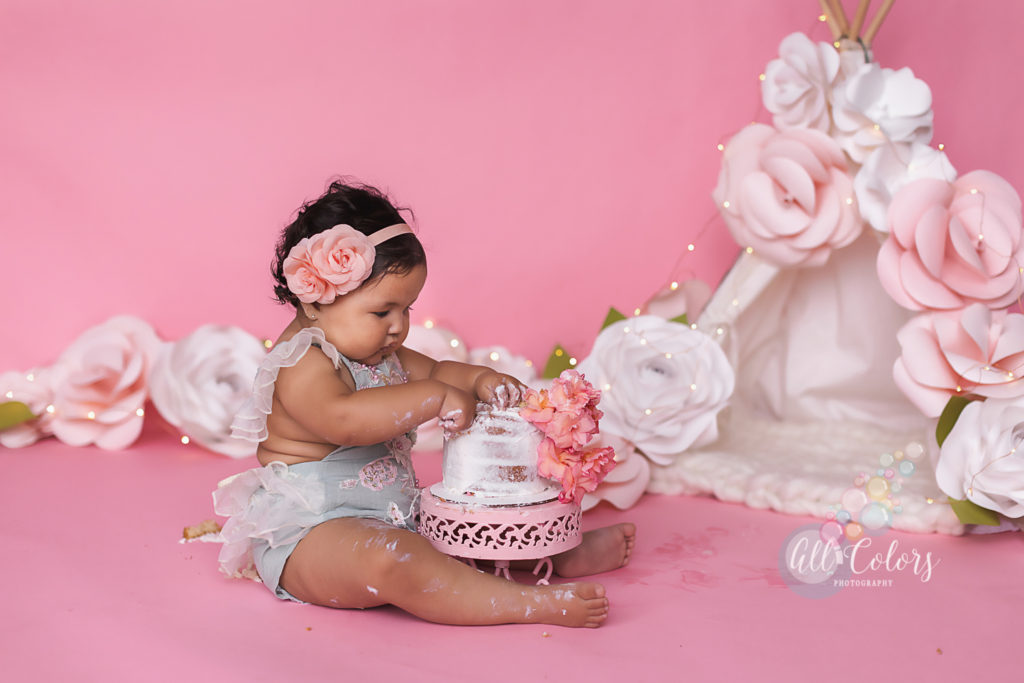 baby girl playing with her cake