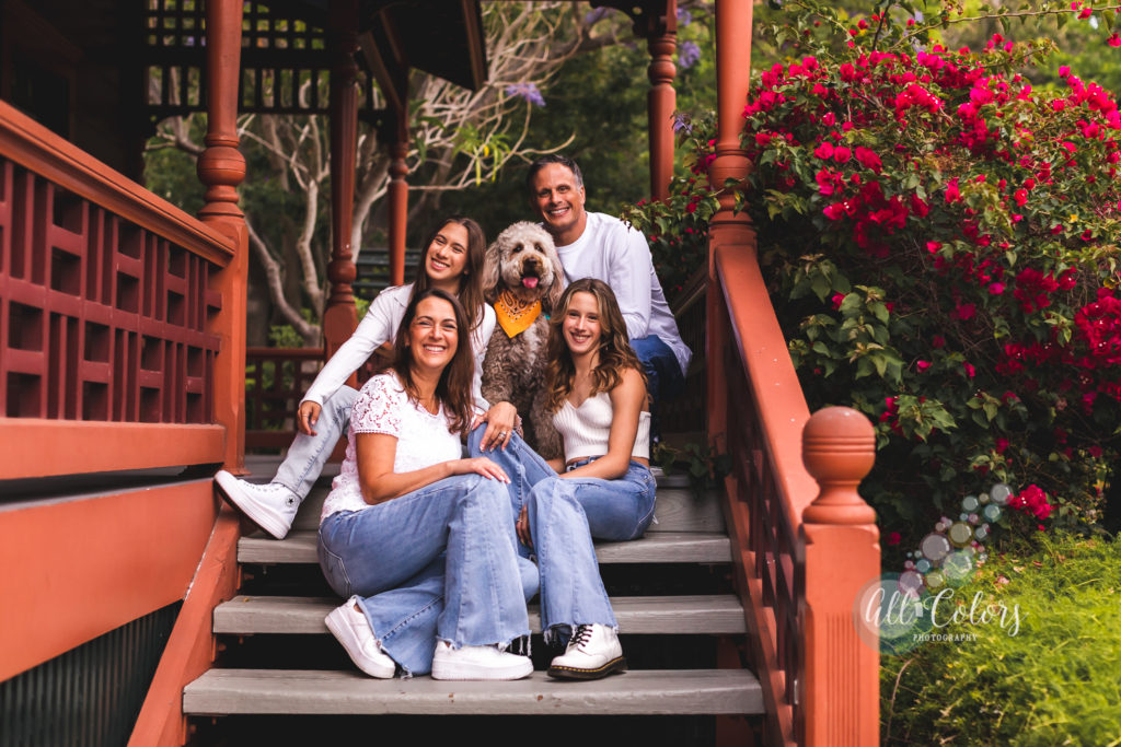family with their dog sitting on a porch
