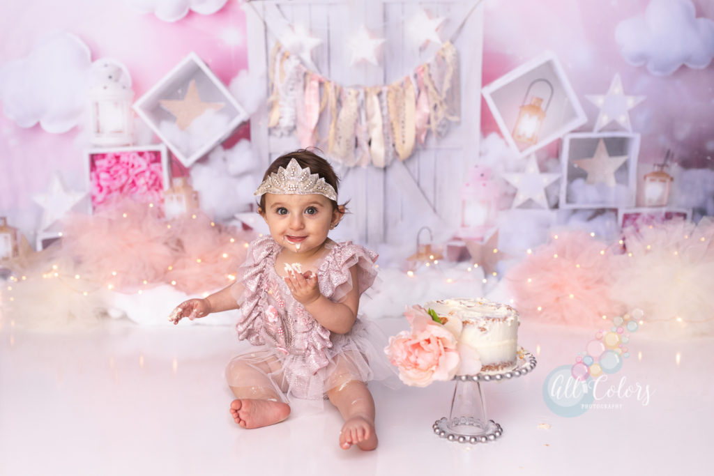 baby girl wearing in pink eating cake