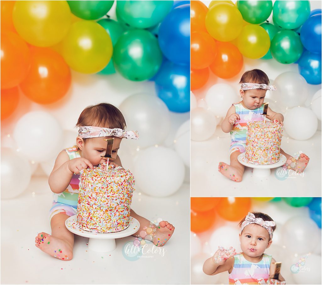 baby eating cake on a rainbow backdrop