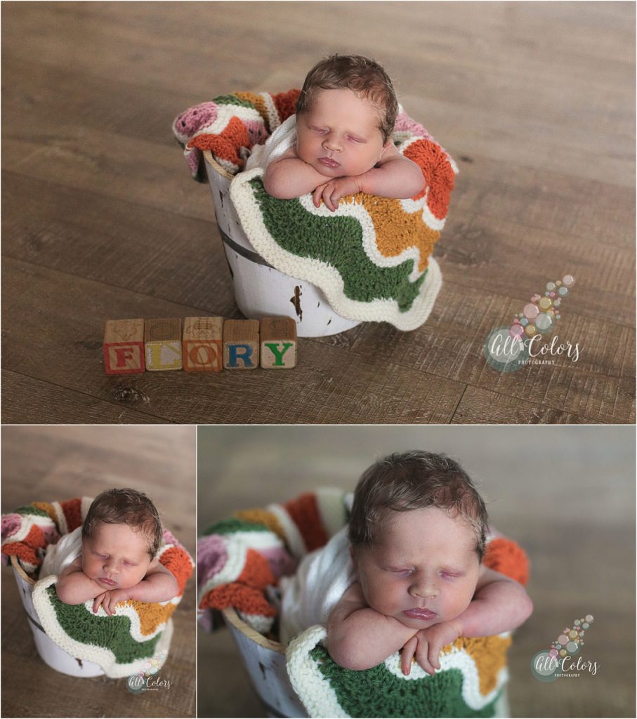 baby sleeping in basket with colorful blanket.