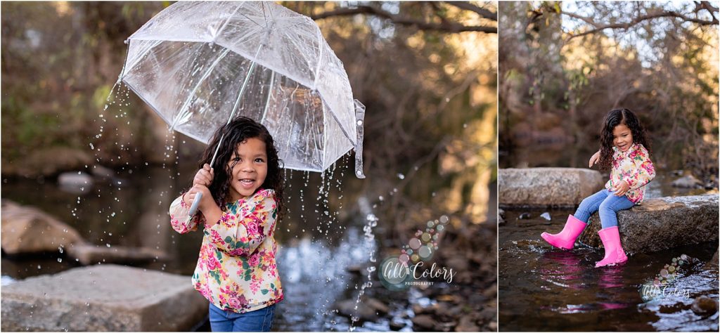 Little girl playing on a water stream with umbrella 