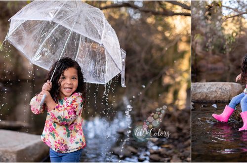 Little girl playing on a water stream with umbrella