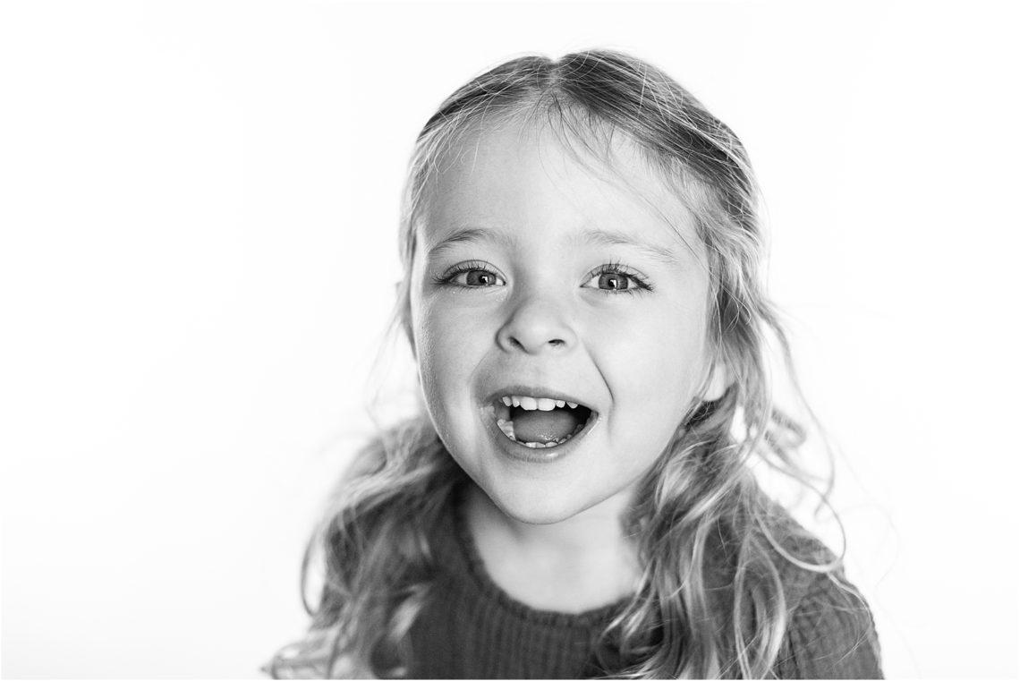 Black and white photo of a preschooler girl smiling
